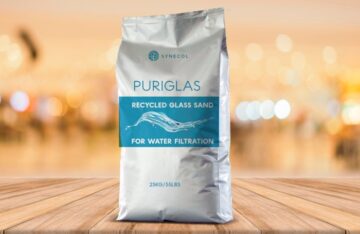 Synecol Puriglas bag of recycled glass sand for water filtration displayed on wooden surface with blurred background